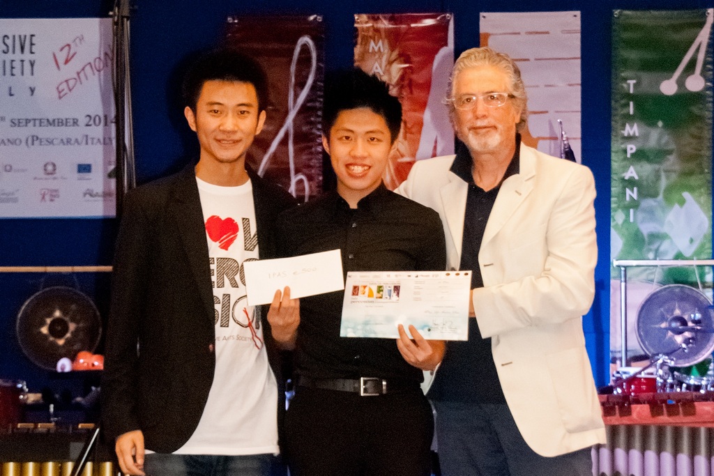 Andrew Chan (centre) receives his prize from the judges.