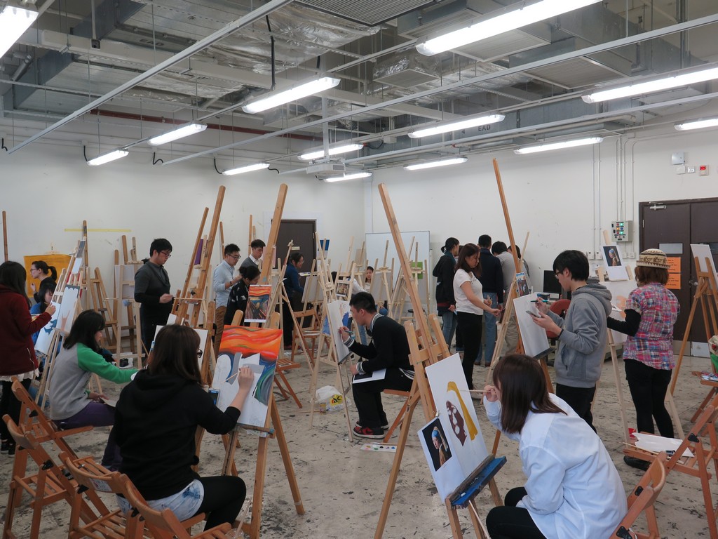 Students painting at individual easels at the Academy of Visual Arts Building.