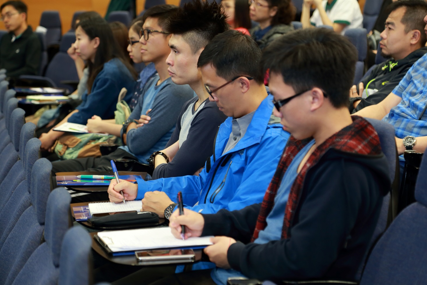 The audience taking notes eagerly on the captivating discussions.