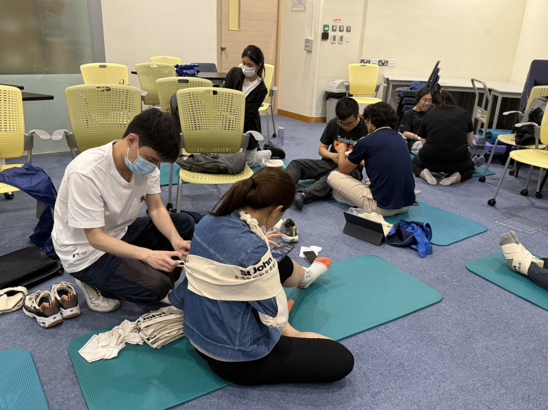 同學互相進行包紮練習。