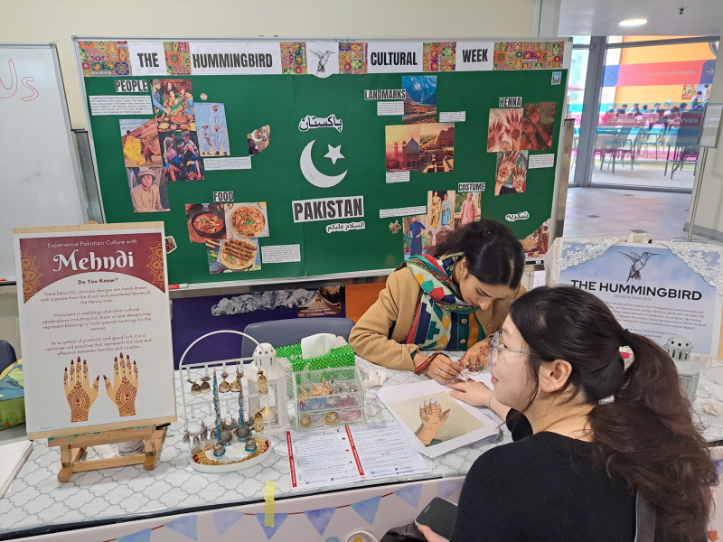 A student having her mehndi (henna) body art drawn.