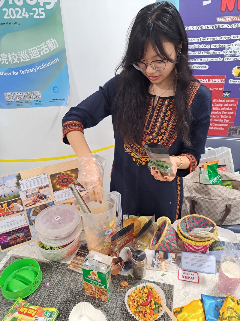 A student preparing Chatta Patta, a Nepalese snack combining dry ramen, puffed rice, and spices, for guests.