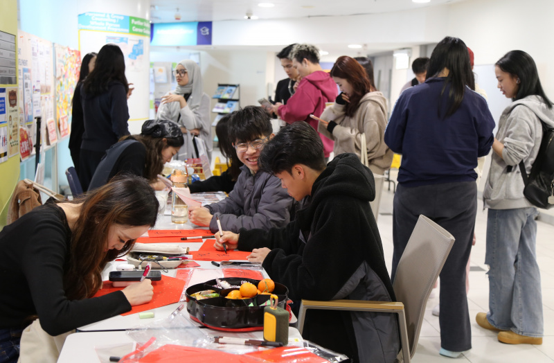 同学撰写挥春，笔划间传递着新春祝福。